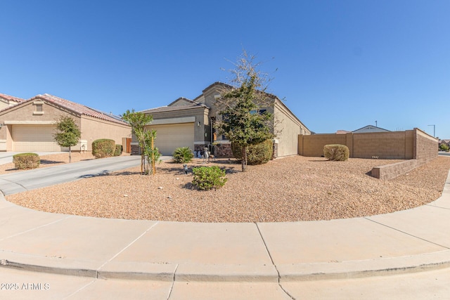 view of front of home featuring driveway, an attached garage, fence, and stucco siding