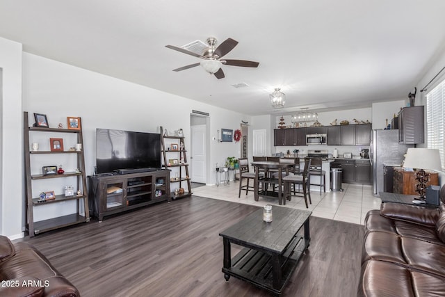 living area featuring light wood finished floors, visible vents, and a ceiling fan