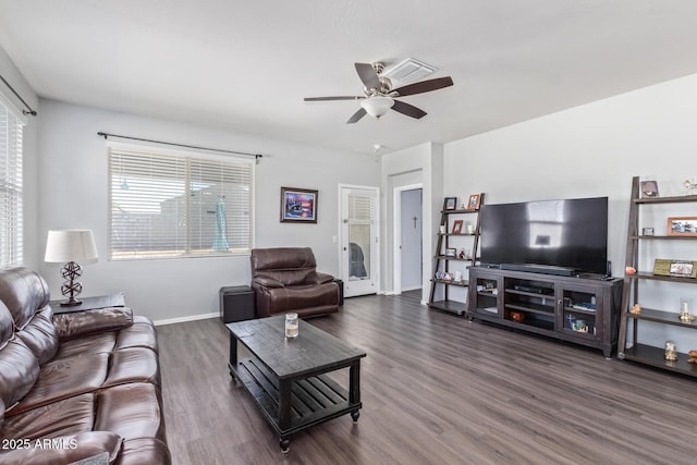 living area with baseboards, a ceiling fan, and wood finished floors