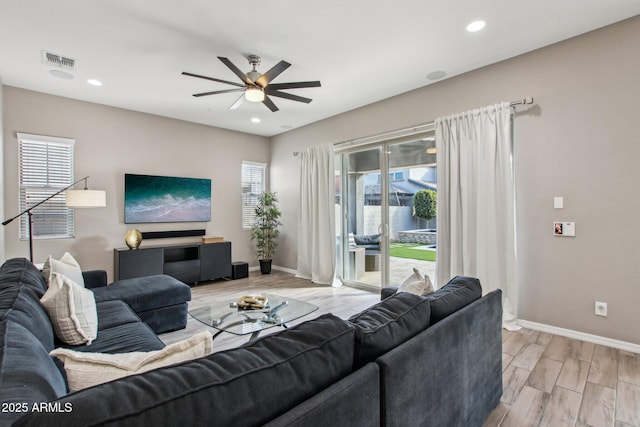 living room featuring ceiling fan and light hardwood / wood-style floors