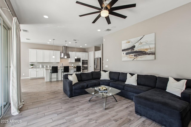 living room featuring sink and ceiling fan