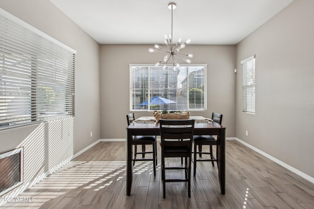 dining area with hardwood / wood-style flooring and an inviting chandelier