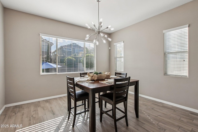 dining space featuring hardwood / wood-style flooring and a notable chandelier