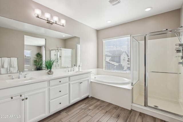 bathroom featuring vanity, hardwood / wood-style floors, and plus walk in shower