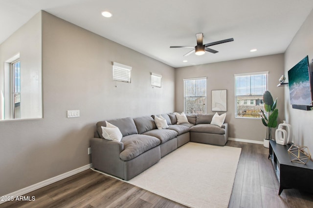 living room with dark hardwood / wood-style flooring and ceiling fan