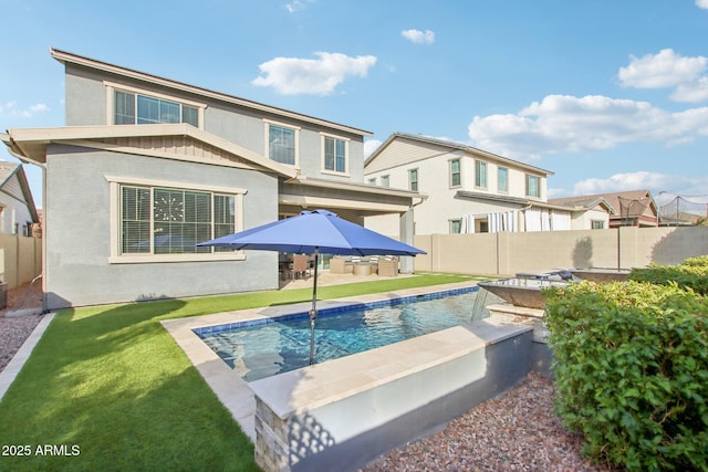 back of property featuring a fenced in pool and a yard