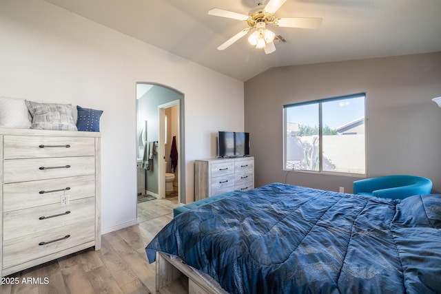 bedroom featuring lofted ceiling, light wood-type flooring, ceiling fan, and connected bathroom