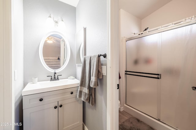 bathroom with vanity, walk in shower, toilet, and hardwood / wood-style floors