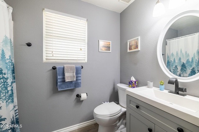 bathroom featuring toilet and vanity