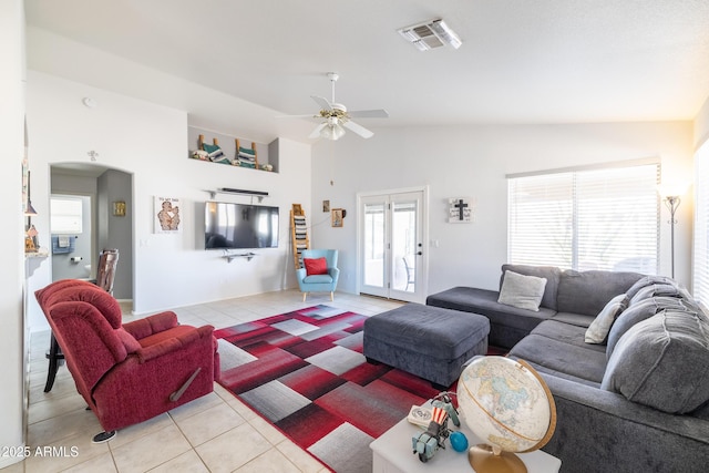 tiled living room with lofted ceiling, ceiling fan, and a healthy amount of sunlight