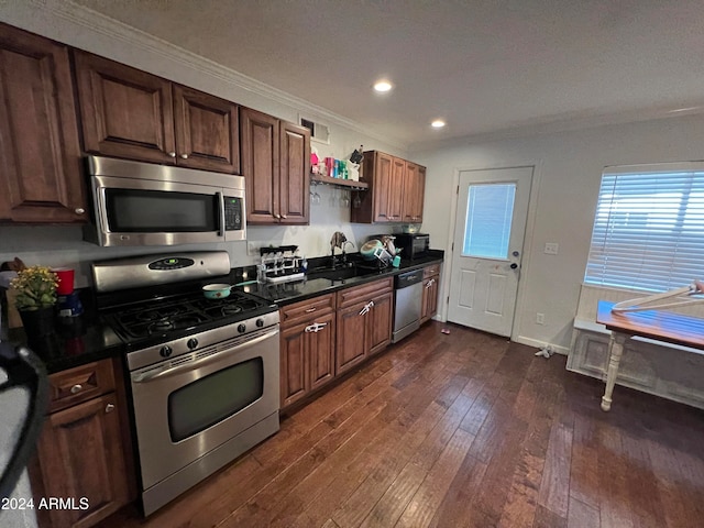 kitchen with appliances with stainless steel finishes, ornamental molding, dark wood-type flooring, and sink