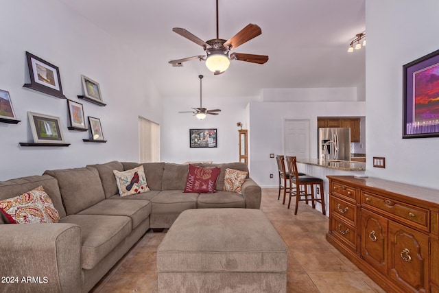 tiled living room with a high ceiling and ceiling fan