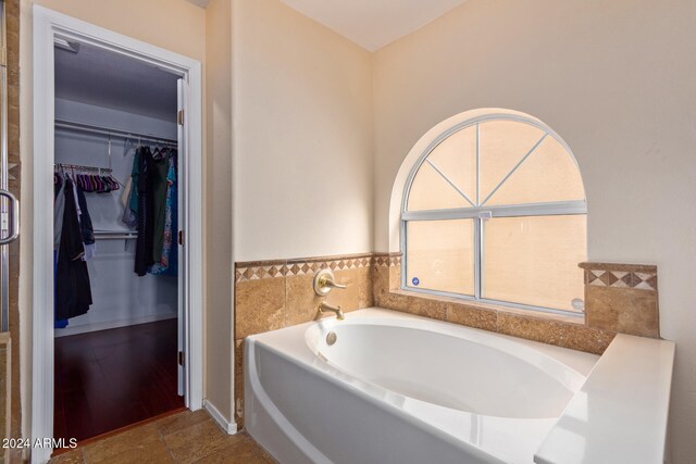 bathroom with tile patterned floors and a washtub