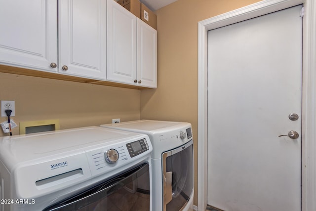 laundry room with washer and clothes dryer and cabinets