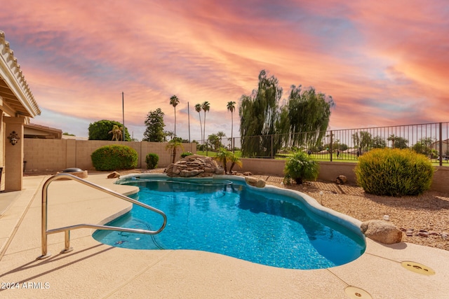 pool at dusk featuring a patio area