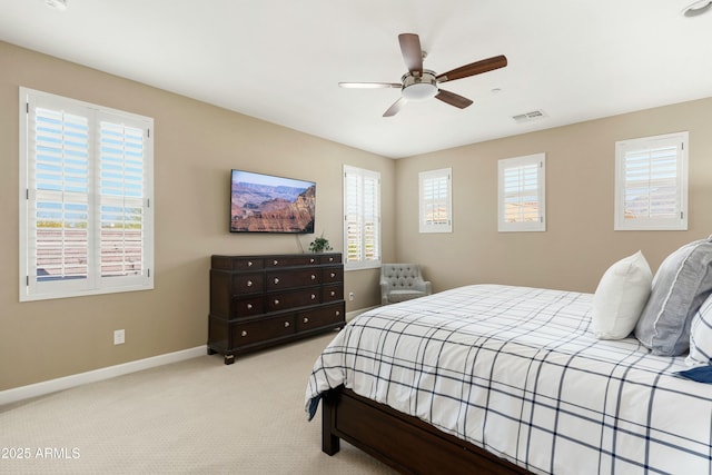 carpeted bedroom with a ceiling fan, visible vents, baseboards, and multiple windows