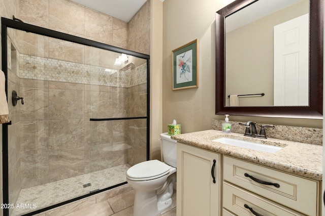 bathroom with vanity, a shower stall, and toilet