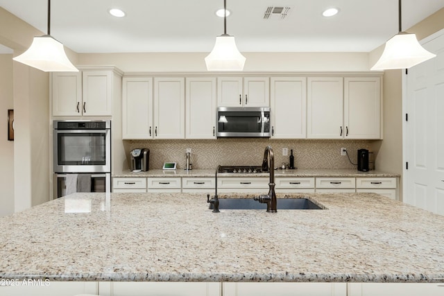 kitchen featuring visible vents, appliances with stainless steel finishes, decorative backsplash, and a sink