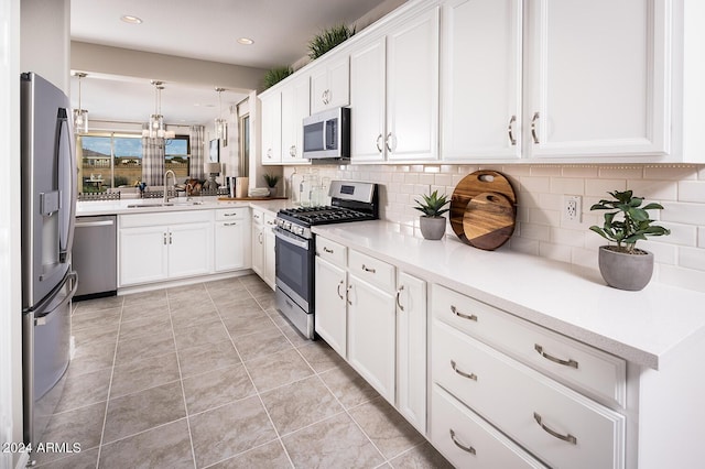 kitchen featuring white cabinets, appliances with stainless steel finishes, a sink, light countertops, and backsplash