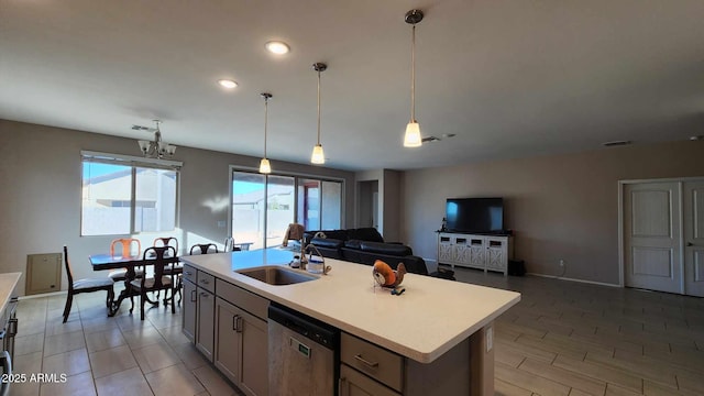 kitchen featuring sink, decorative light fixtures, a center island with sink, dishwasher, and a chandelier