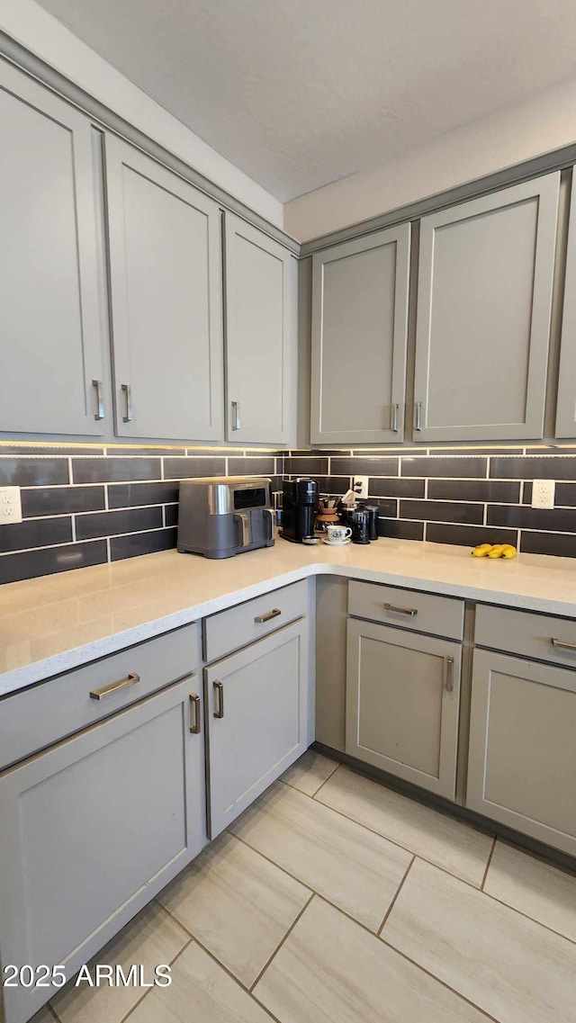 kitchen with tasteful backsplash and gray cabinetry