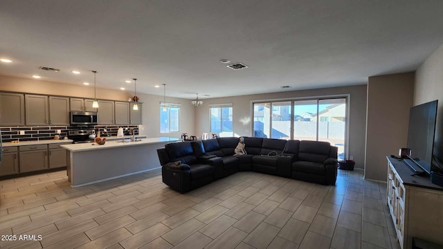 living room featuring a notable chandelier and sink