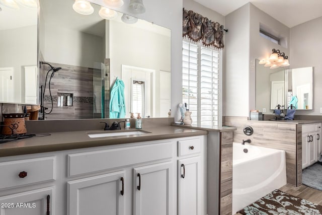 full bath with tiled shower, vanity, a garden tub, and wood finished floors