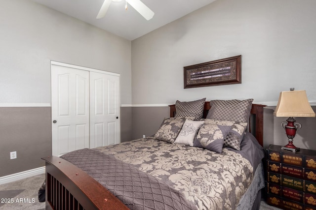 carpeted bedroom with a closet, baseboards, lofted ceiling, and ceiling fan