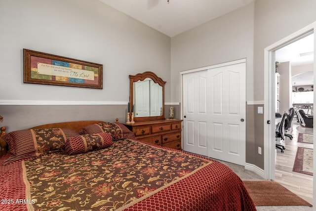 bedroom with a ceiling fan, arched walkways, vaulted ceiling, a closet, and carpet flooring