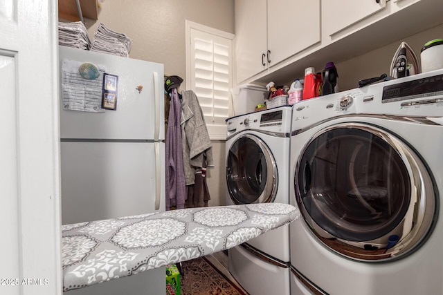 laundry room featuring washing machine and clothes dryer and cabinet space