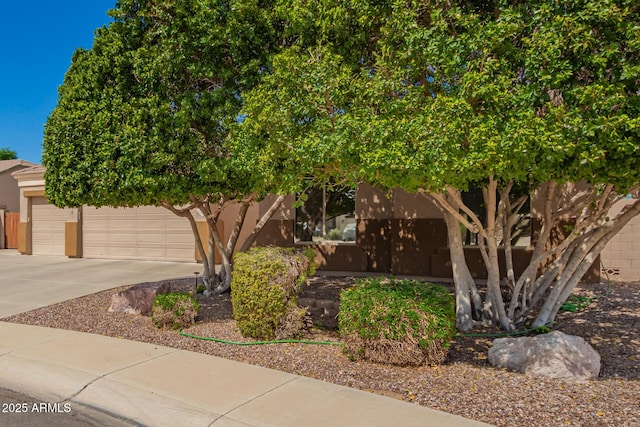 view of front of house featuring a garage, driveway, and stucco siding