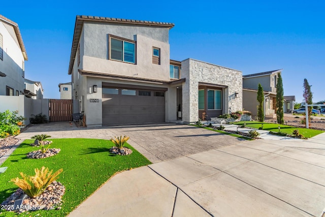 1501 E Rakestraw Ln, Gilbert, AZ 85298 - view of front of property featuring stucco siding, decorative driveway, an attached garage, stone siding, and a gate