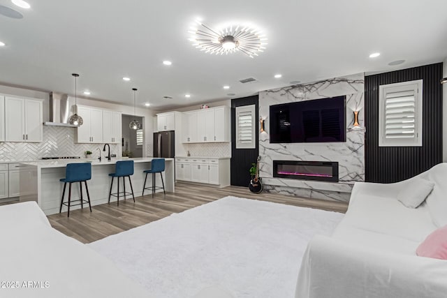 1501 E Rakestraw Ln, Gilbert, AZ 85298 - living area with a high end fireplace, light wood-type flooring, and recessed lighting