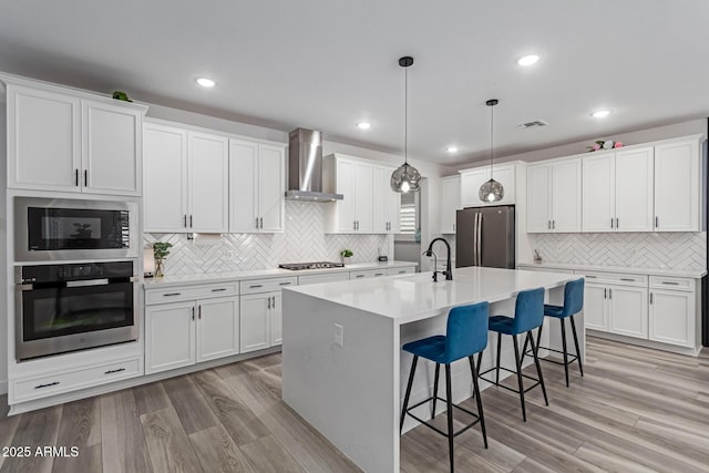 1501 E Rakestraw Ln, Gilbert, AZ 85298 - kitchen with appliances with stainless steel finishes, wall chimney exhaust hood, a sink, decorative backsplash, and white cabinetry