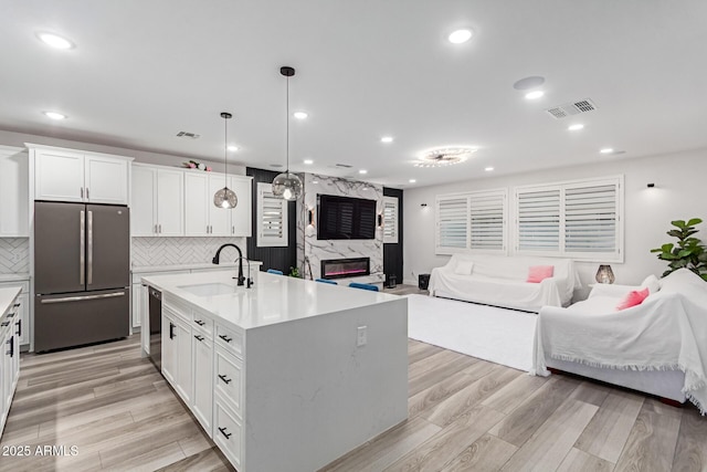 1501 E Rakestraw Ln, Gilbert, AZ 85298 - kitchen with freestanding refrigerator, a sink, open floor plan, dishwashing machine, and light countertops