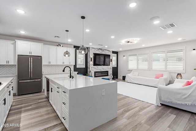 1501 E Rakestraw Ln, Gilbert, AZ 85298 - kitchen featuring freestanding refrigerator, a sink, open floor plan, dishwasher, and light countertops