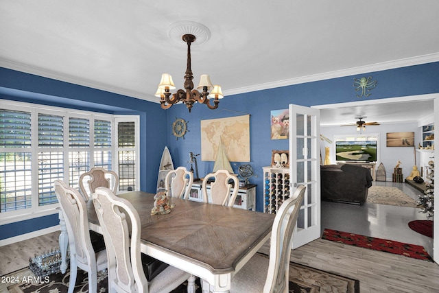 dining area with ceiling fan with notable chandelier, wood-type flooring, and ornamental molding