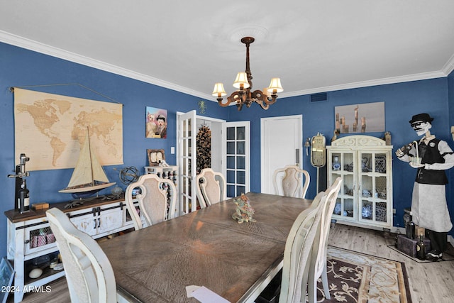 dining room with a chandelier, crown molding, french doors, and wood-type flooring