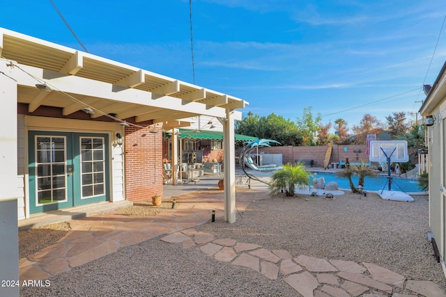 view of patio with french doors and a swimming pool