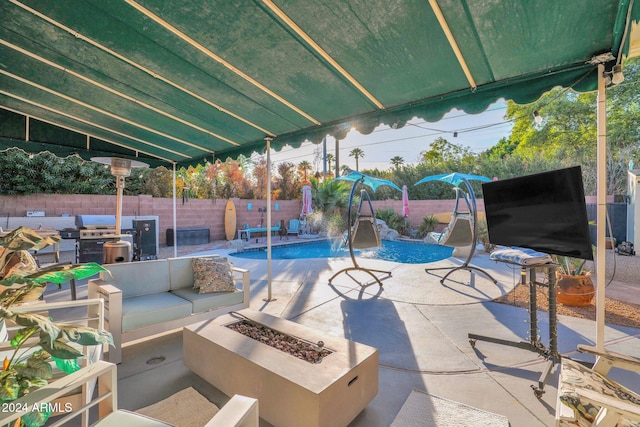 view of patio / terrace featuring a fenced in pool, pool water feature, and an outdoor living space with a fire pit