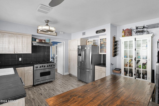 kitchen featuring light brown cabinets, ventilation hood, light hardwood / wood-style flooring, decorative backsplash, and appliances with stainless steel finishes