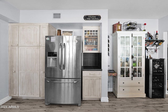 kitchen featuring stainless steel fridge with ice dispenser, wood-type flooring, and cream cabinetry