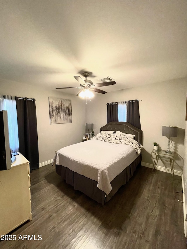 bedroom with baseboards, ceiling fan, and dark wood-style flooring
