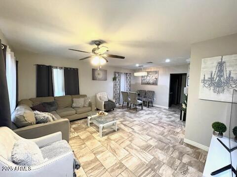 living room featuring baseboards and a ceiling fan