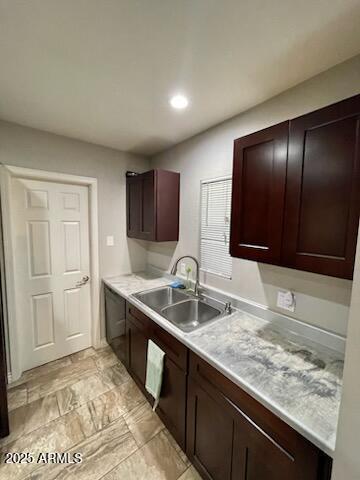 kitchen with dark brown cabinets, light countertops, a sink, and recessed lighting