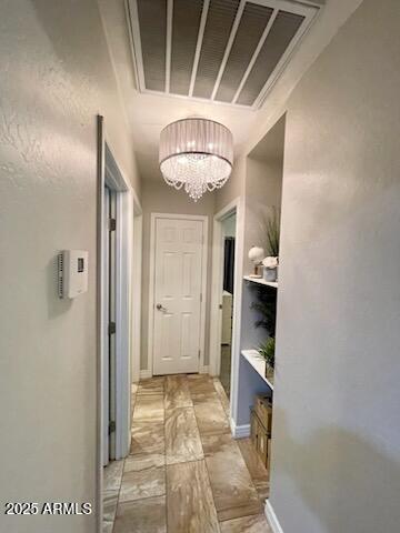 hall with visible vents and a chandelier