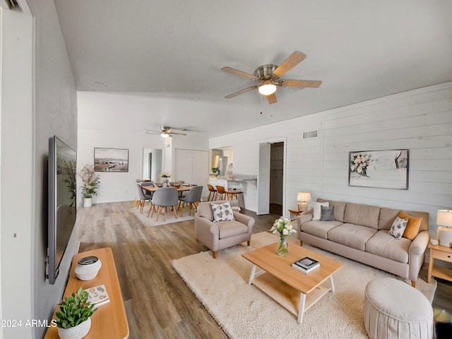 living room with wood-type flooring and ceiling fan