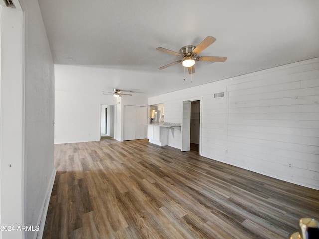 unfurnished living room featuring dark hardwood / wood-style floors and ceiling fan