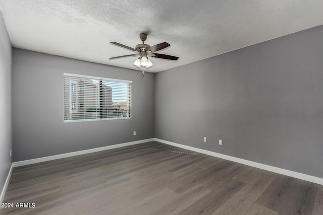 unfurnished room featuring baseboards, a textured ceiling, wood finished floors, and a ceiling fan