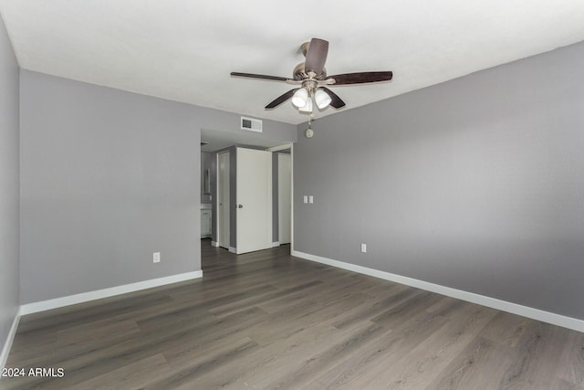 unfurnished room featuring visible vents, a ceiling fan, dark wood-style flooring, and baseboards